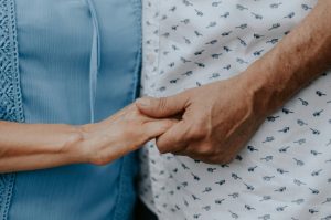 Paciente de mãos dadas com familiar, representando a importância do testamento vital para garantir autonomia sobre cuidados médicos